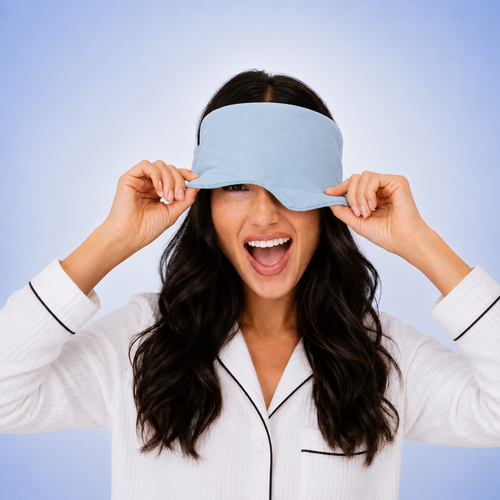Woman wearing a light blue sleep mask with a plain background