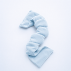 Light blue eye mask weighted on a light gray background