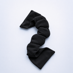 Black weighted eye mask for sleeping on a white background