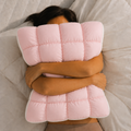 Person wrapped in a pink quilted blanket on a bed