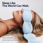 Woman wearing a blue strap-free weighted eye mask with text 'Sleep Like The World Can Wait.'